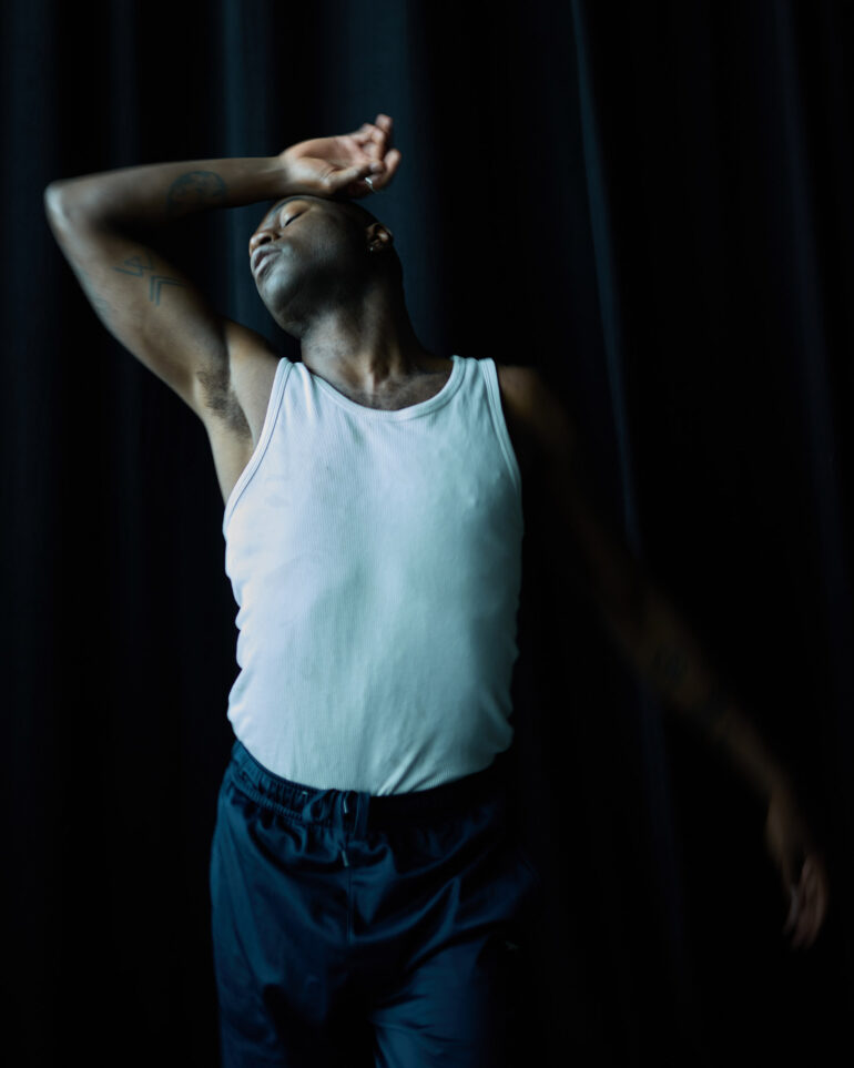 Folu Odimayo poses in front of a black backdrop