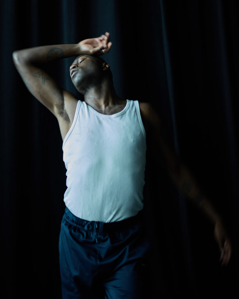 Folu Odimayo poses in front of a black backdrop