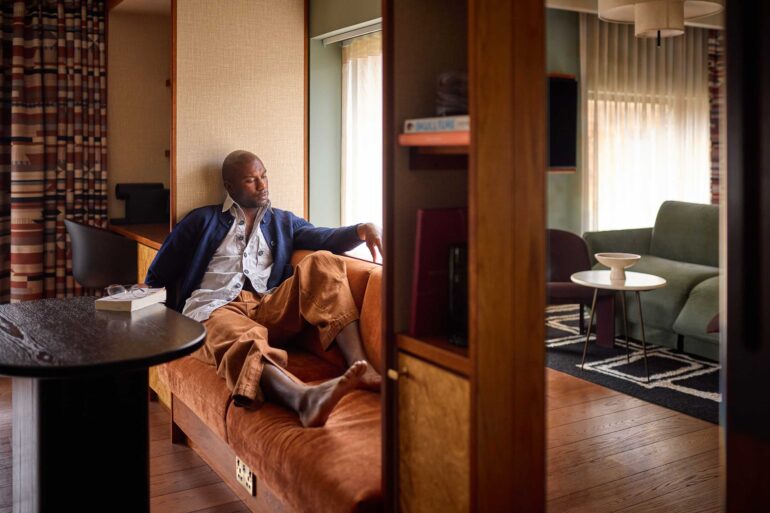 Folu Odimayo relaxes on a sofa in his room at the Sir Devonshire Square Hotel in London, UK