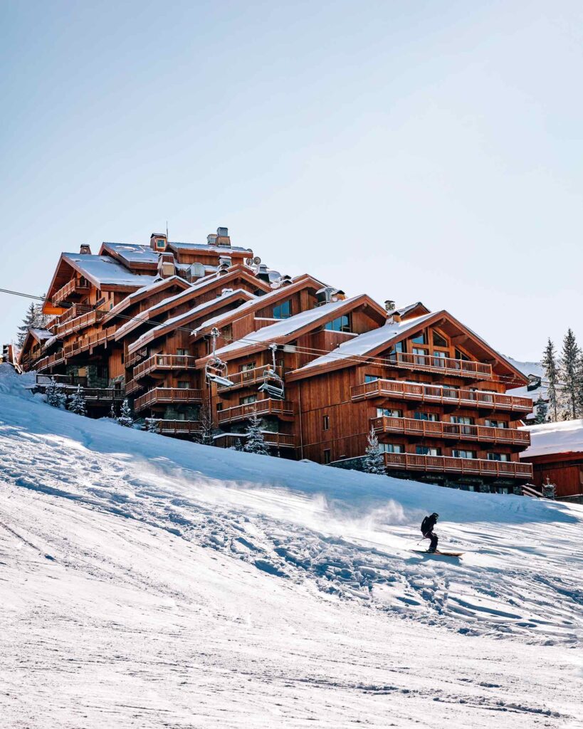 A skier on the pistes in front of Hotel Le Coucou, Méribel, France