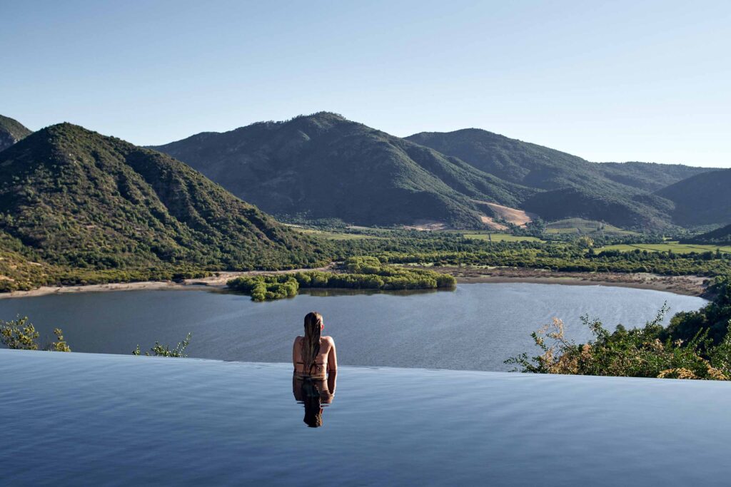 A guest looks out over the valley from the pool at Vik Chile, Millahue Valley, Cachapoal, Chile