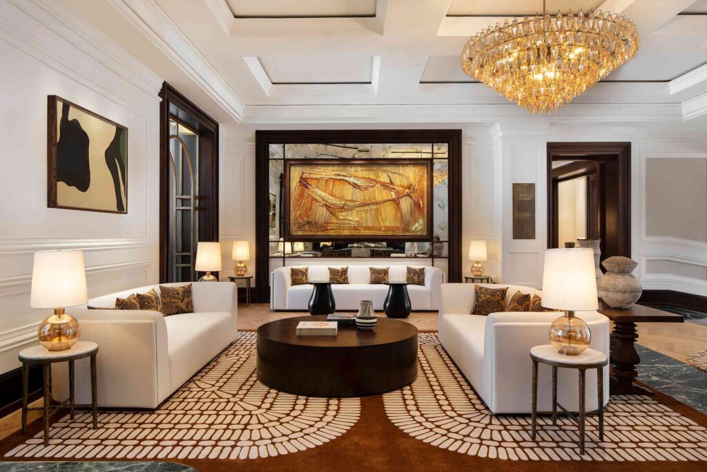 Lobby interiors at the Cape Grace, featuring Afro-contemporary furniture – white sofas, amber glass lampshades, artwork and chandelier, ochre patterned carpets