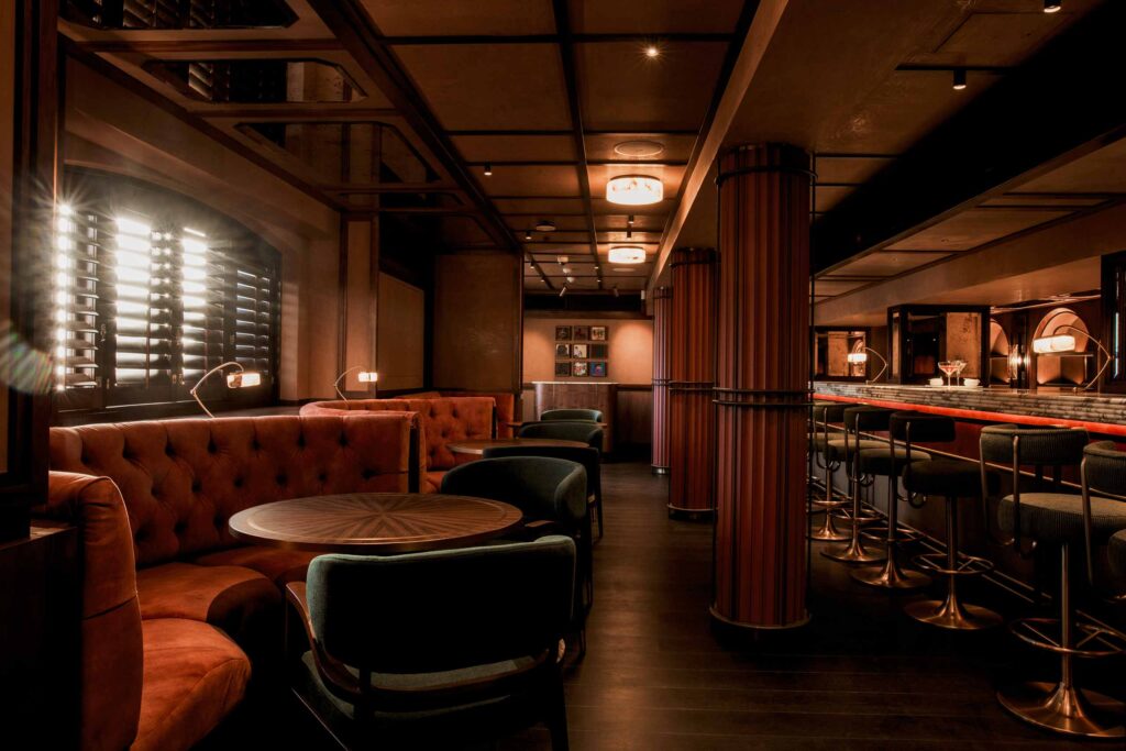 Moody, dimly lit, Bascule Bar, with gentlemen's club like contemporary interiors and wood paneling