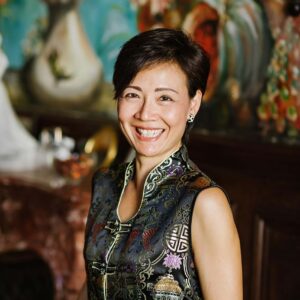 Portrait of Jeanette Ho, Vice President, Head of Brand-Commercial, Banyan Group. Jeanette is a Singaporean Chinese women with short hair and she wears a gold chinese cheongsam