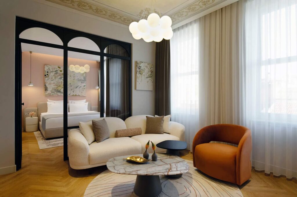 A bulbous sofa and contemporary light fixture, part of a suite at Casa Foscolo, a Member of Design Hotels, Istanbul, Türkiye