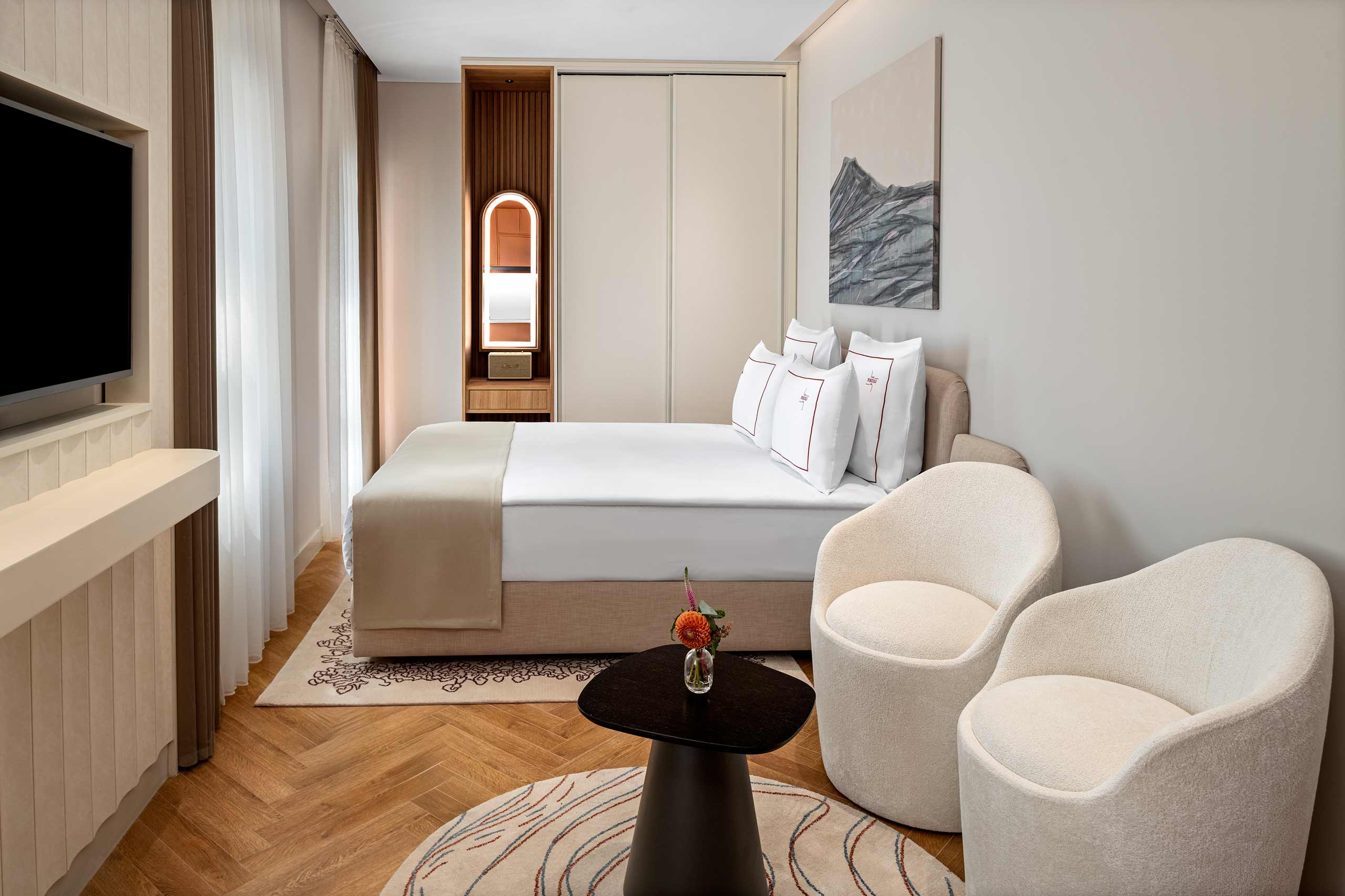 A modern, minimalist bedroom alongside two seats at Casa Foscolo, a Member of Design Hotels, Istanbul, Türkiye