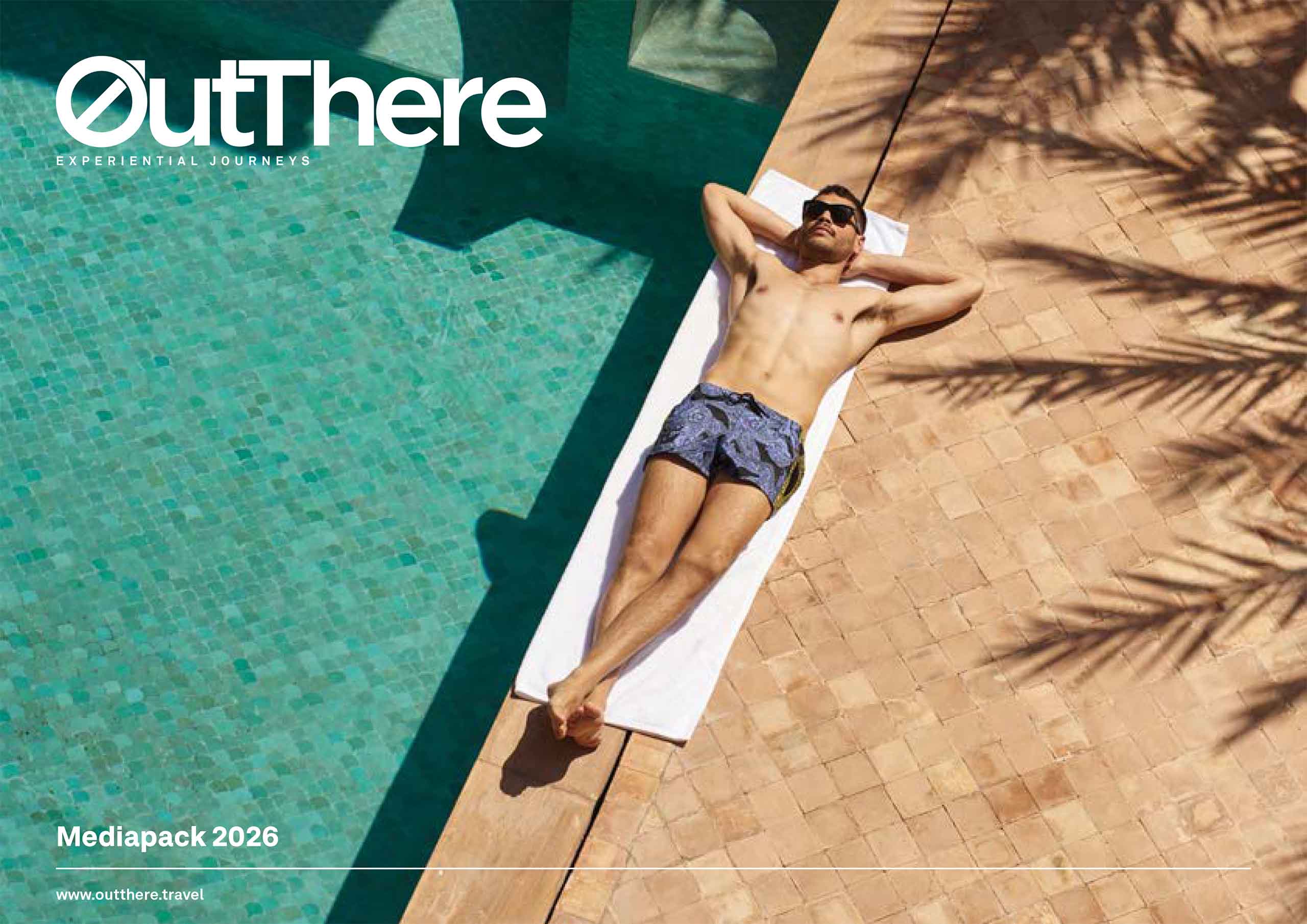 Cover image of OutThere mediapack with model lounging by the pool in his swimming trunks, with his arms resting behind his head, while the shadow of palm fronds are silhouetted on the tiles