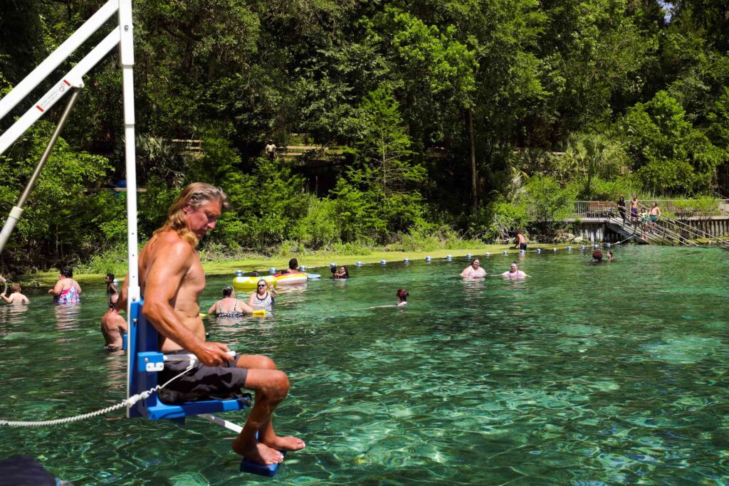 A disabled traveller uses a device lowering him into a lake in Cedar Key