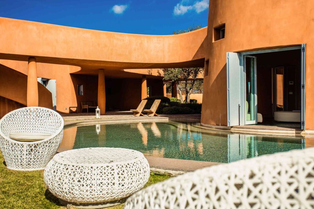 The curves of the terracota Villas at Is Molas, Sardinia, with plunge pool and sunloungers on a sunny day