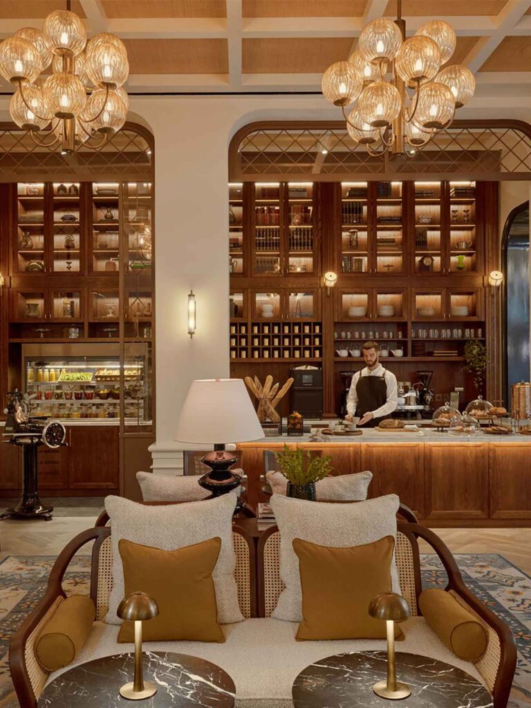 Whiteleys Bar with custom armchair and apothecary style wood display units at Six Senses London