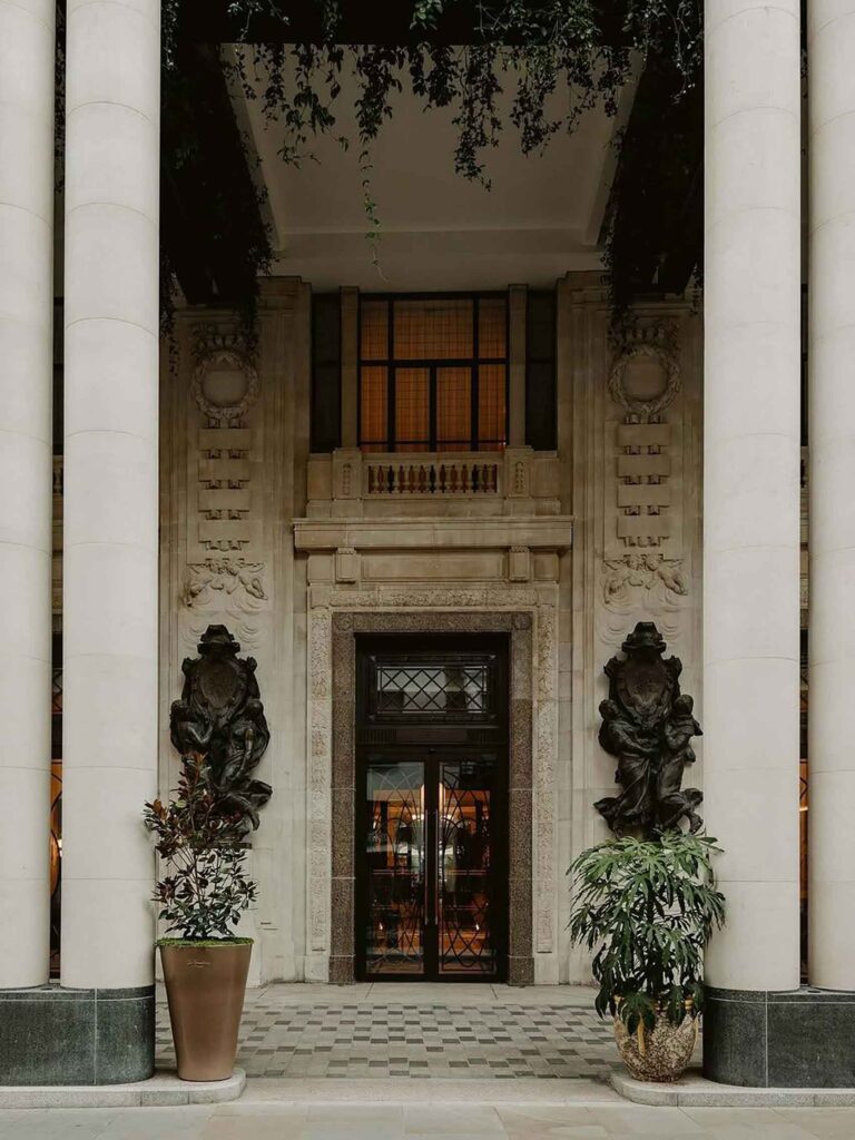 Edwardian entrance flanked by bronze sculptures and column at The Whiteleys, the front porch of Six Senses London