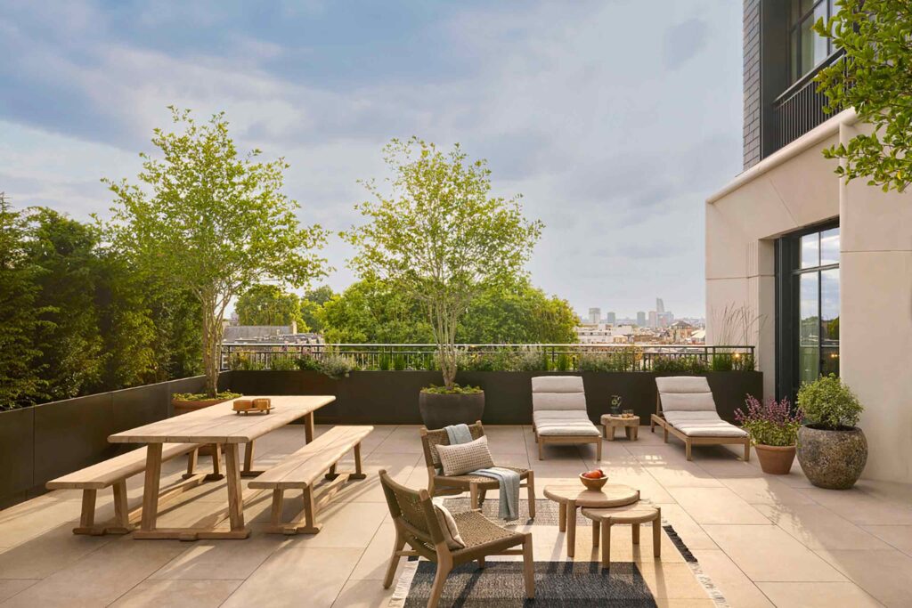 Terrace at Six Senses London, with garden furniture, potted trees and plants and view over London