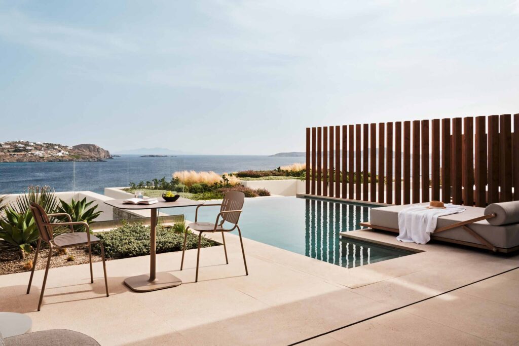 Private terrace and plunge pool at The Coast Bill & Coo, with sun lounger, table and chair looking over the pool and sea beyond