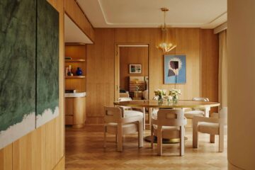 Suite interior design, featuring dining area with round table and six chairs, honey coloured wood panelling at The Emory, London