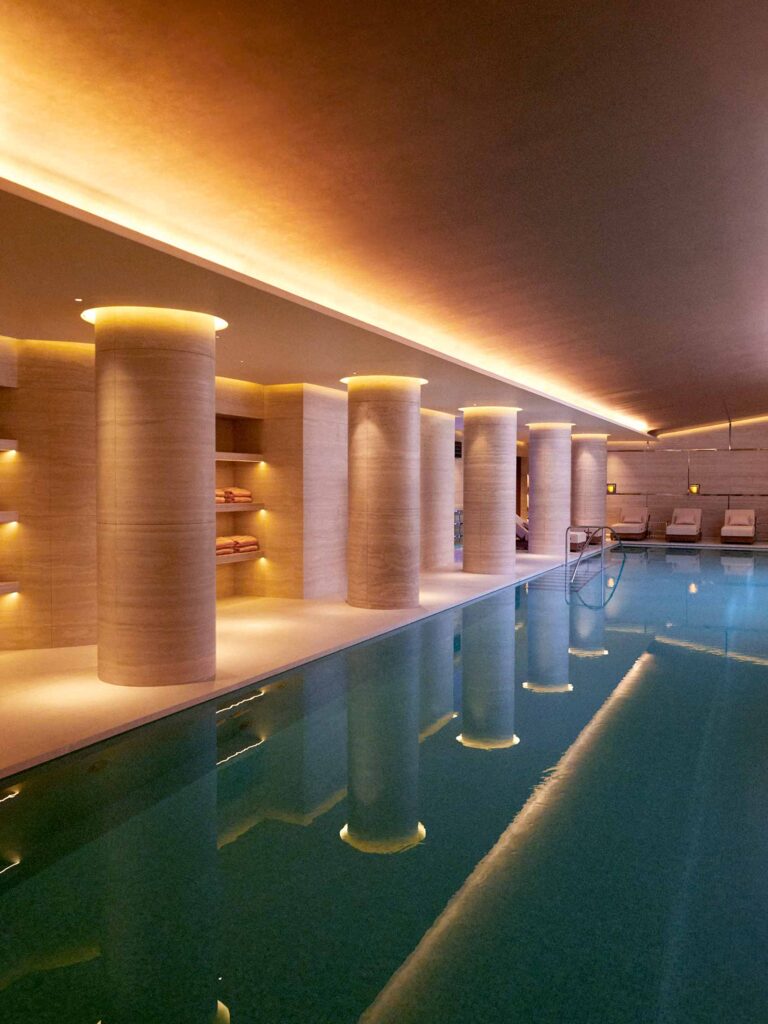 Indoor swimming pool, lit up, at Surenne, the wellness facility at The Emory London