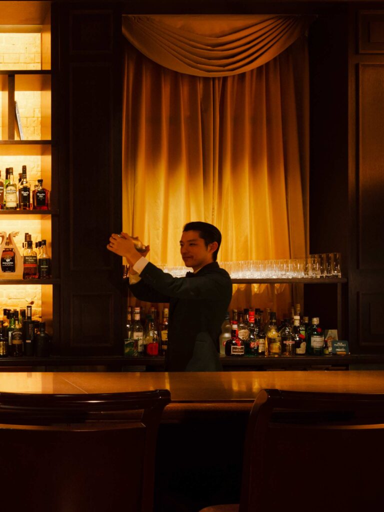 Cocktail barman shaking a cocktail at the bar at the Tokyo Station Hotel