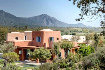 Villas at Is Molas, Sardinia – Massimiliano Fuksas designed villa, a striking orange villa amid greenery with mountains in the background