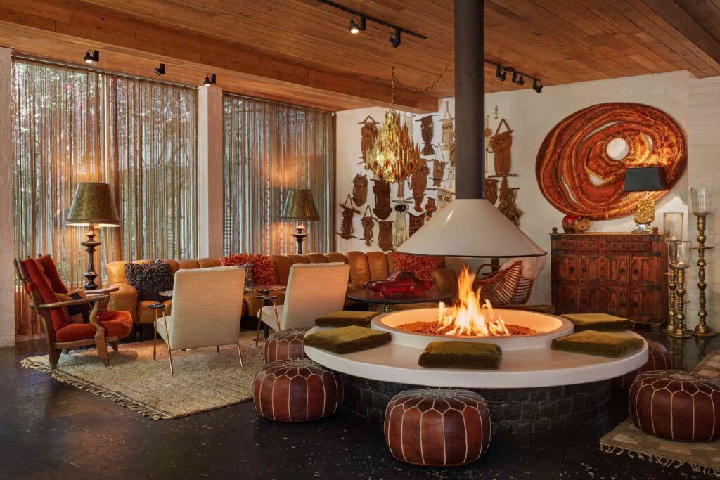 Exotic, African inspired mid century interiors – masks, leather pouffes, and a 70s style firepit at at Parker Palm Springs
