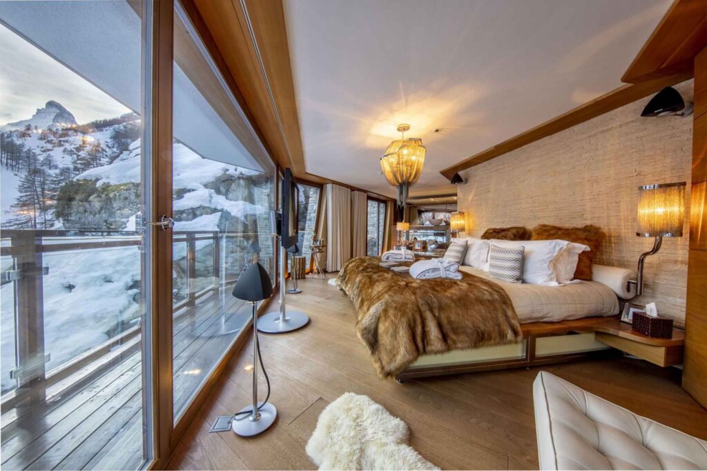 Bedroom of a The luxury chalet company chalet, with deerskin and wool interiors looking out to a terrace and a view of the mountains