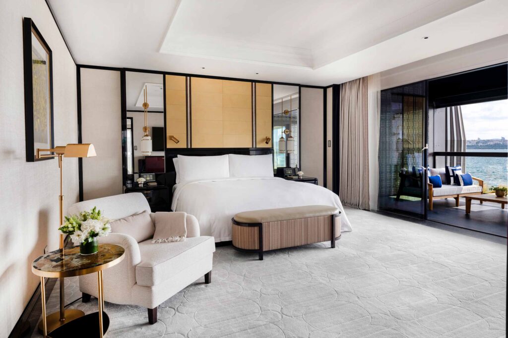 A king-size bed and a balcony offering views of the water inside a Premier Bosphorus Suite