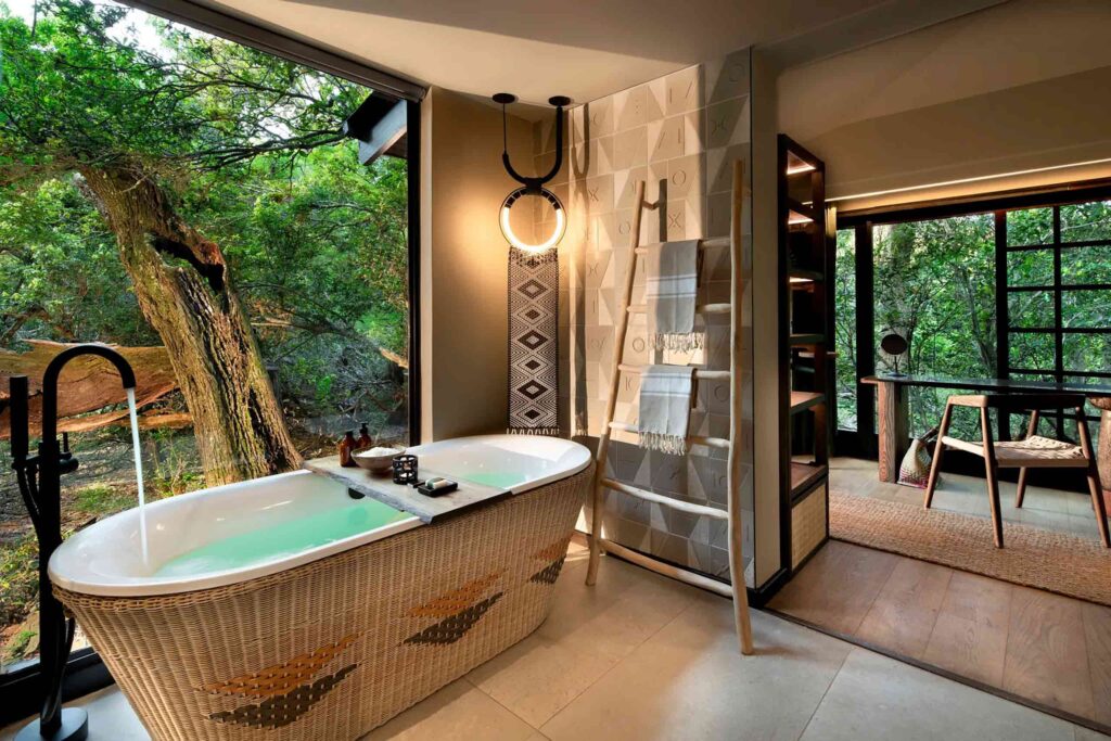 A bathtub with a view of the forest is filling with water at andBeyond Phinda Forest Lodge, KwaZulu-Natal, South Africa