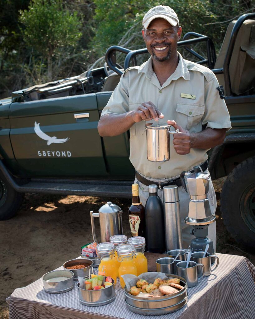 A member of the team prepares coffee and an outdoor breakfast in the bush for guests at andBeyond Phinda Forest Lodge, KwaZulu-Natal, South Africa