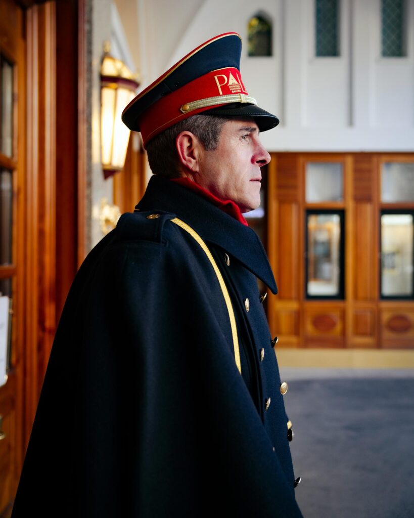 A uniformed porter stands outside the entrance of Badrutt's Palace Hotel, St Moritz, Switzerland