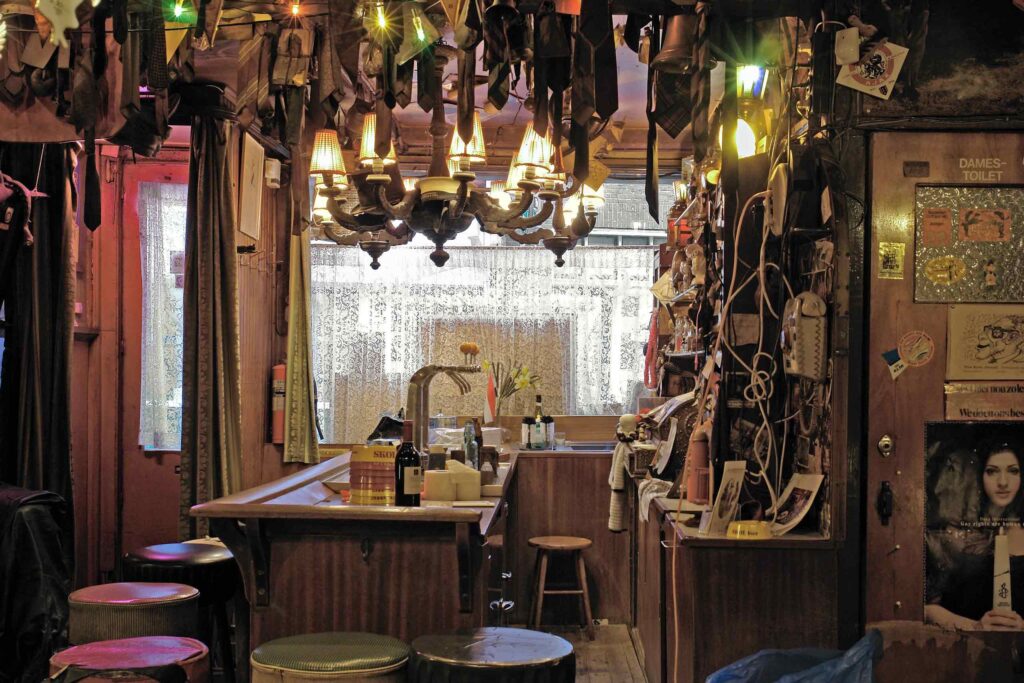 The inside of Café 't Mandje in Amsterdam, with severed ties hanging from the ceiling in a nod to its founder Bet van Beeren