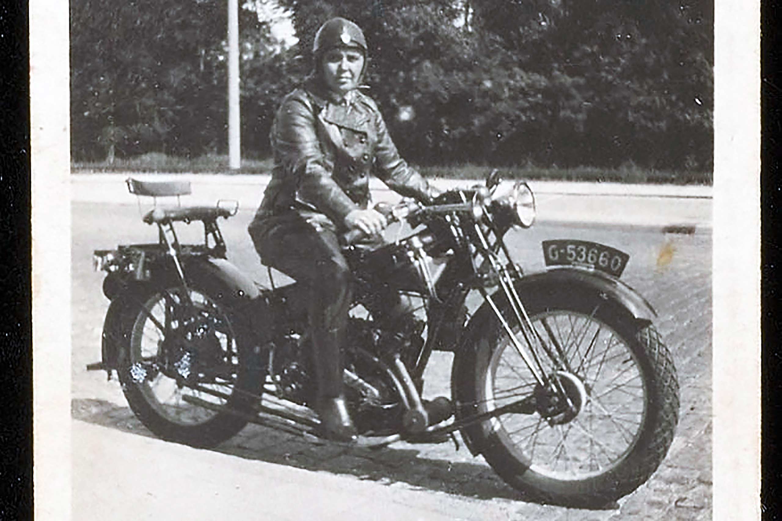 A black-and-white photograph of gay icon and historical Amsterdam bar owner Bet van Beeren on a motorbike