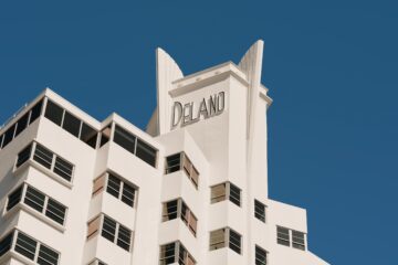 Whitewashed Miami Modernism architectural flourishs of the exterior of the Delano Miami Beach against a clear blue sky