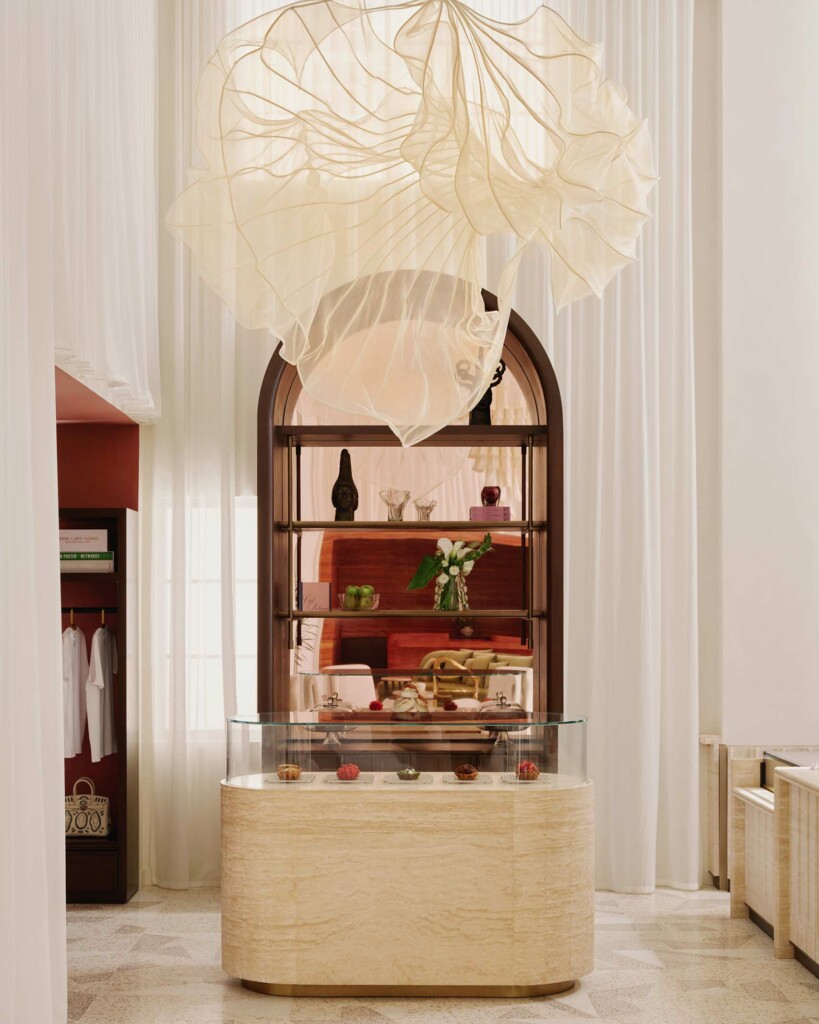 Nothing Finer, the retail concept by Steven Giles in the Delano Miami Beach. This picture shows a white marble display counter and shelf, under a white fabric sculptural chandelier and rouched curtains backdrop