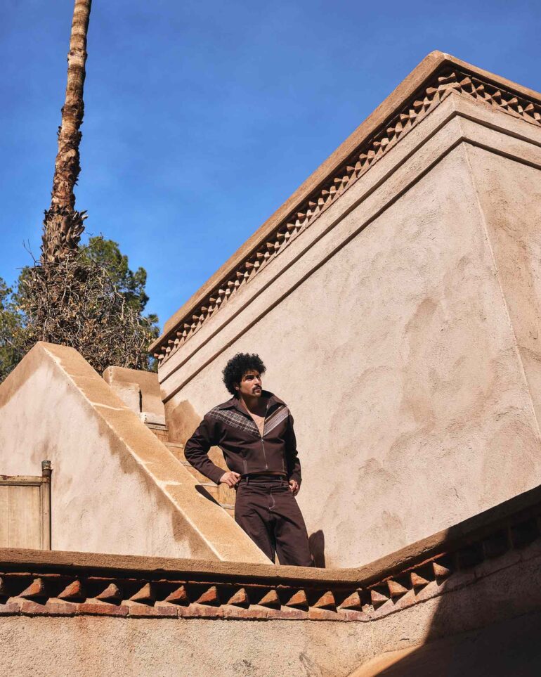 Amran Bennaji wearing a unisex brown jacket while standing on stairs in Marrakech, Morocco