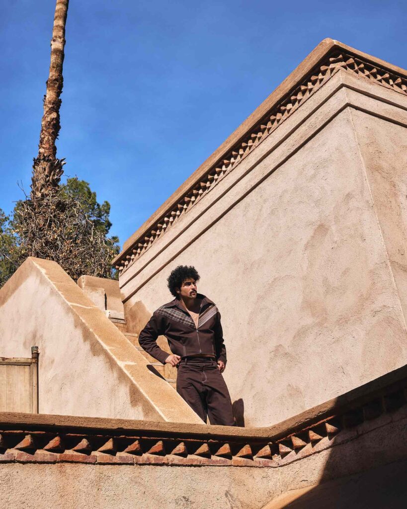 Amran Bennaji wearing a unisex brown jacket while standing on stairs in Marrakech, Morocco