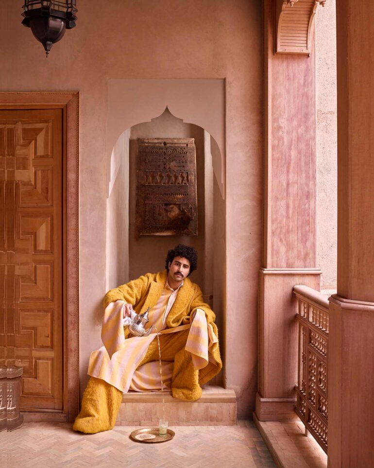 Amran Bennaji pours tea into a beldi glass on a golden tray in Marrakech, Morocco