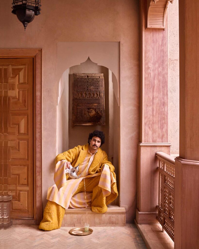Amran Bennaji pours tea into a beldi glass on a golden tray in Marrakech, Morocco