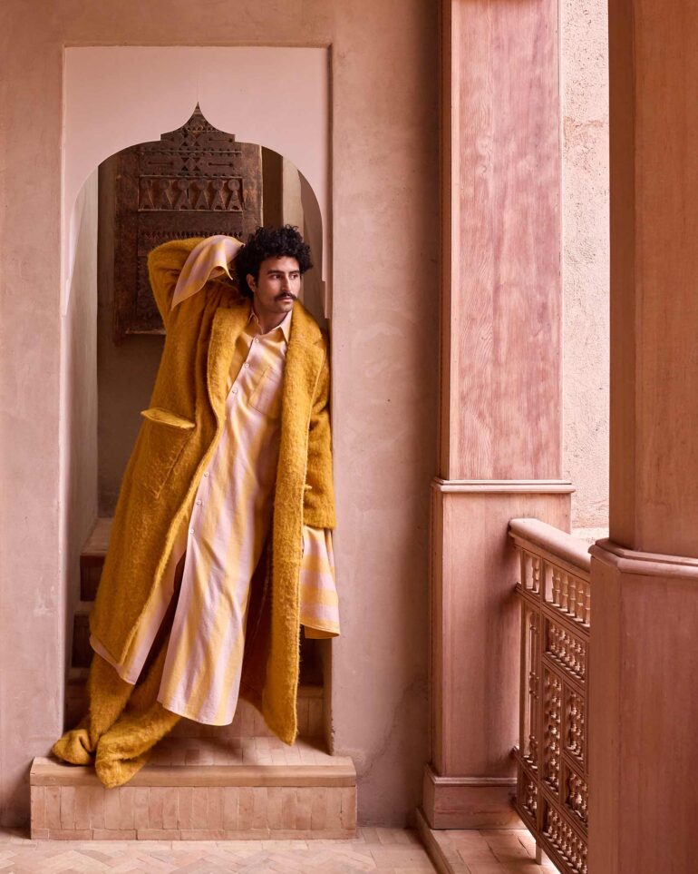 Amran Bennaji wearing a yellow blanket coat by Marrekeshi Life in Marrakech, Morocco