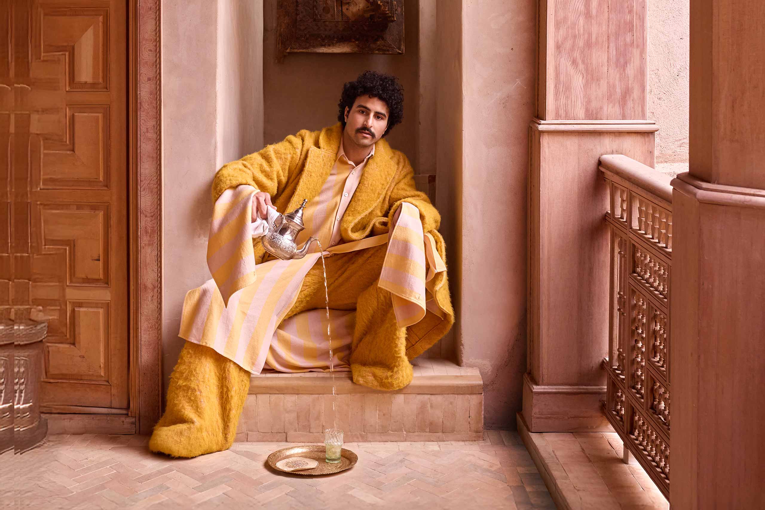 Amran Bennaji pours tea into a beldi glass on a golden tray in Marrakech, Morocco