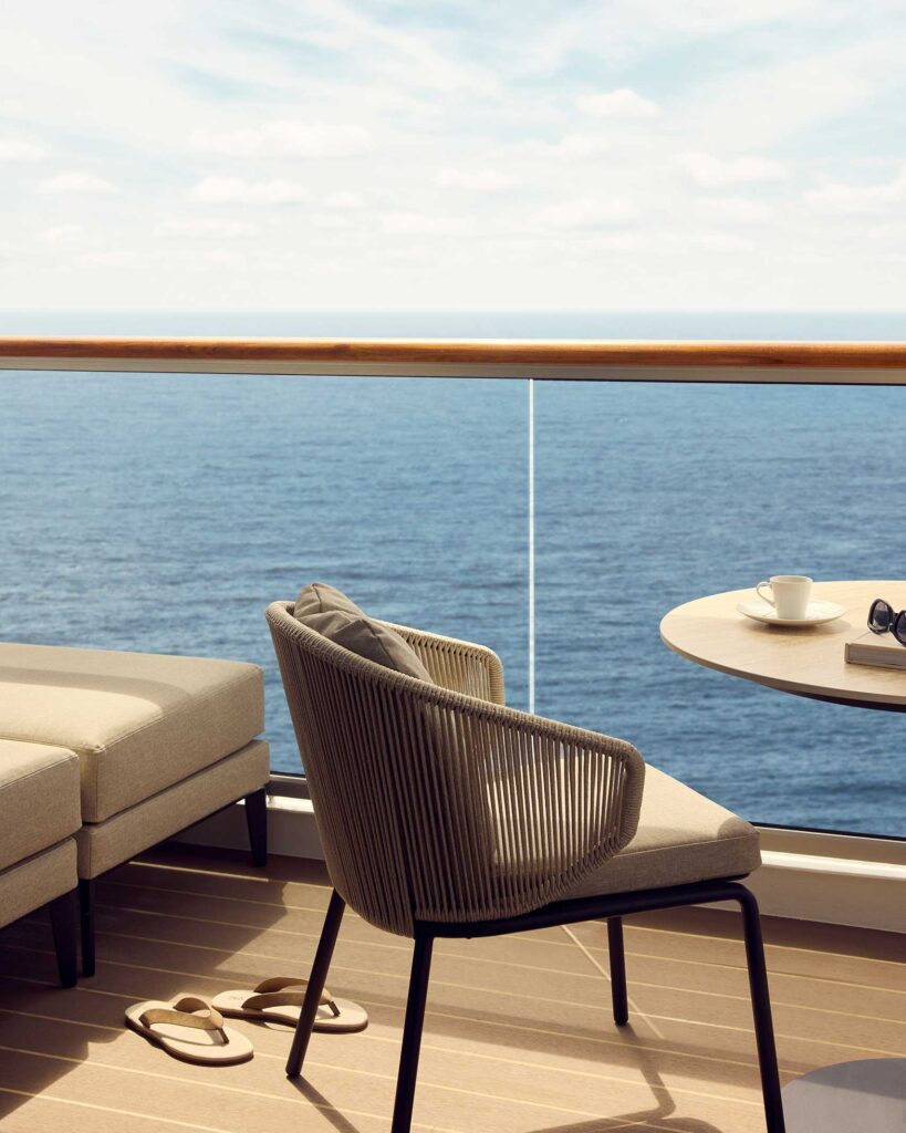 Penthouse terrace on EXPLORA I with outdoor chair, espresso cup on table and flip flops on floor