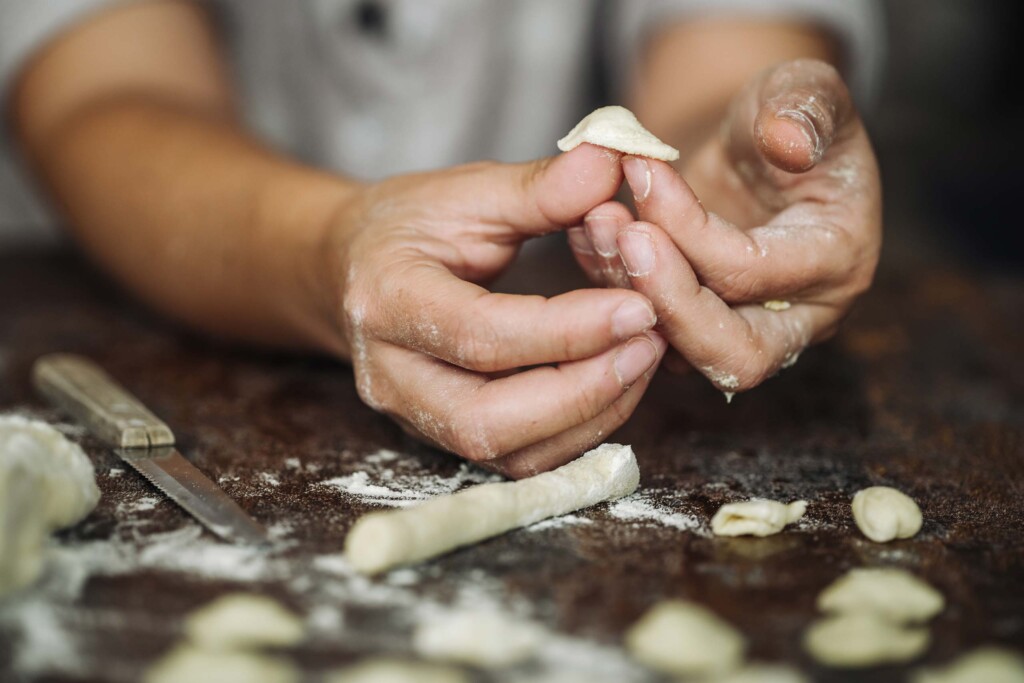 Chefs hands folding pasta in Italy