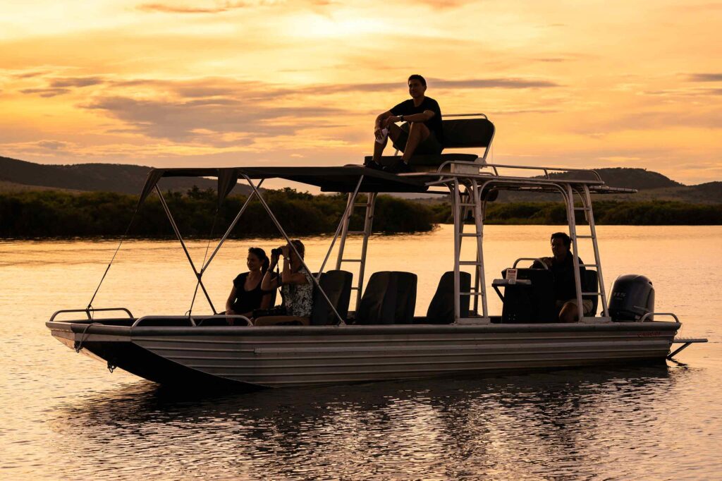 Visitors on a boat on a lake during sunset in Akagera National Park, Rwanda