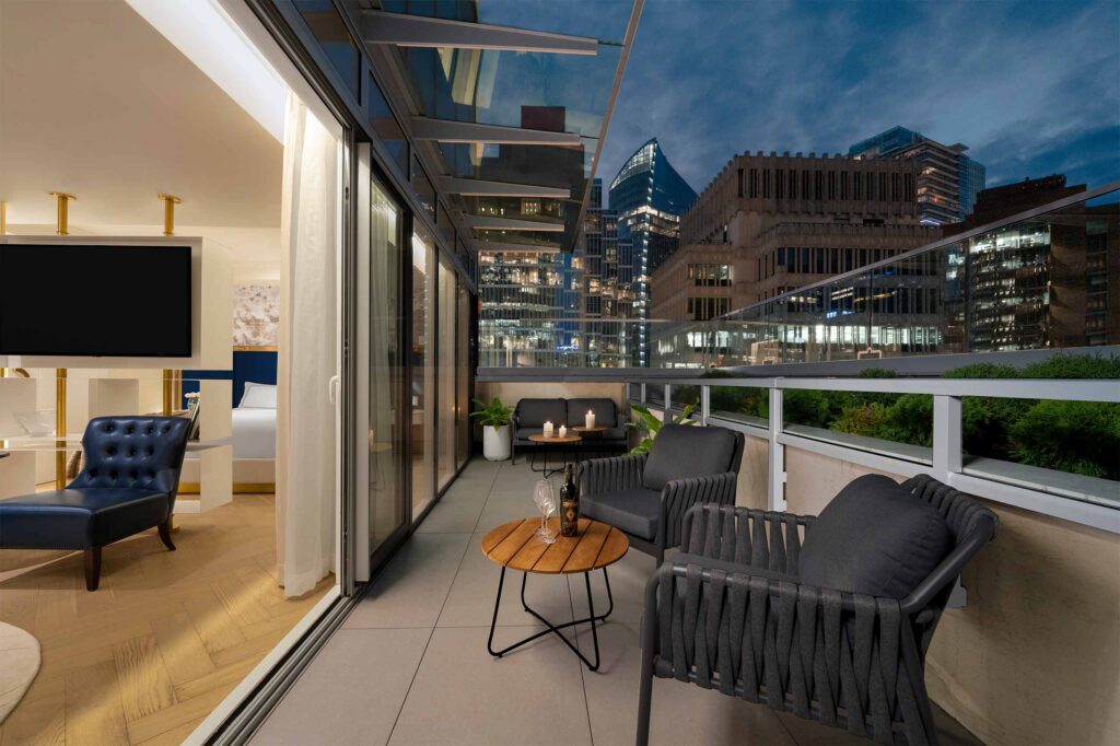 A warmly lit outdoor space part of a penthouse overlooking the skyline of Vancouver, Canada
