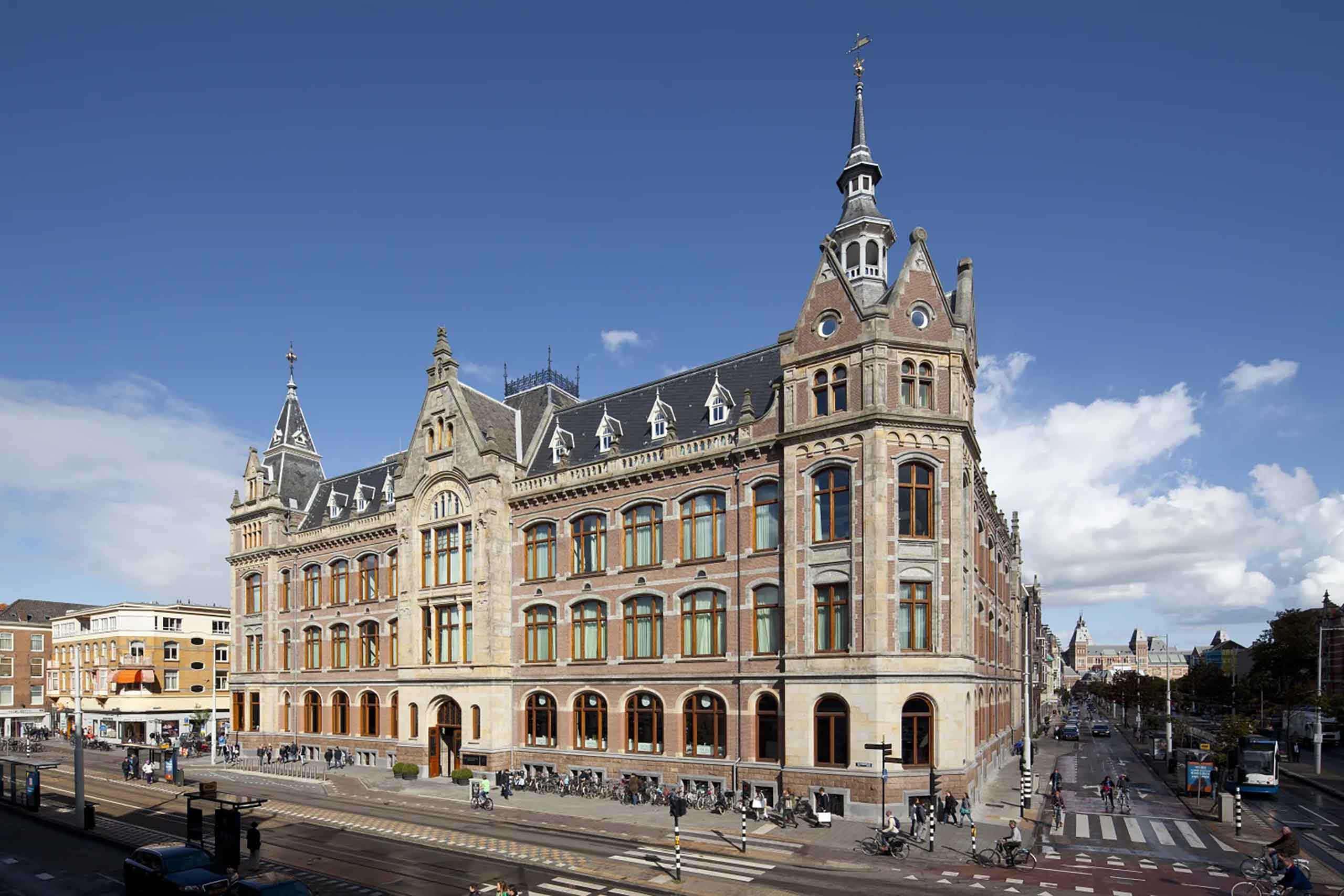 Exterior of the Mandarin Oriental Conservatorium Amsterdam with its stone structure, geometric turrets and 19th century Neo-Renaissance architecture