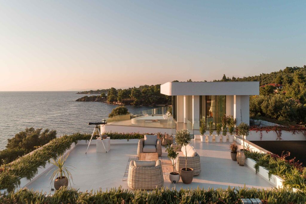 A contemporarily-designed, white villa with a large outdoor viewing space overlooking the sea at Villa Gaia, a property in the portfolio of Le Collectionist by Max Aniort