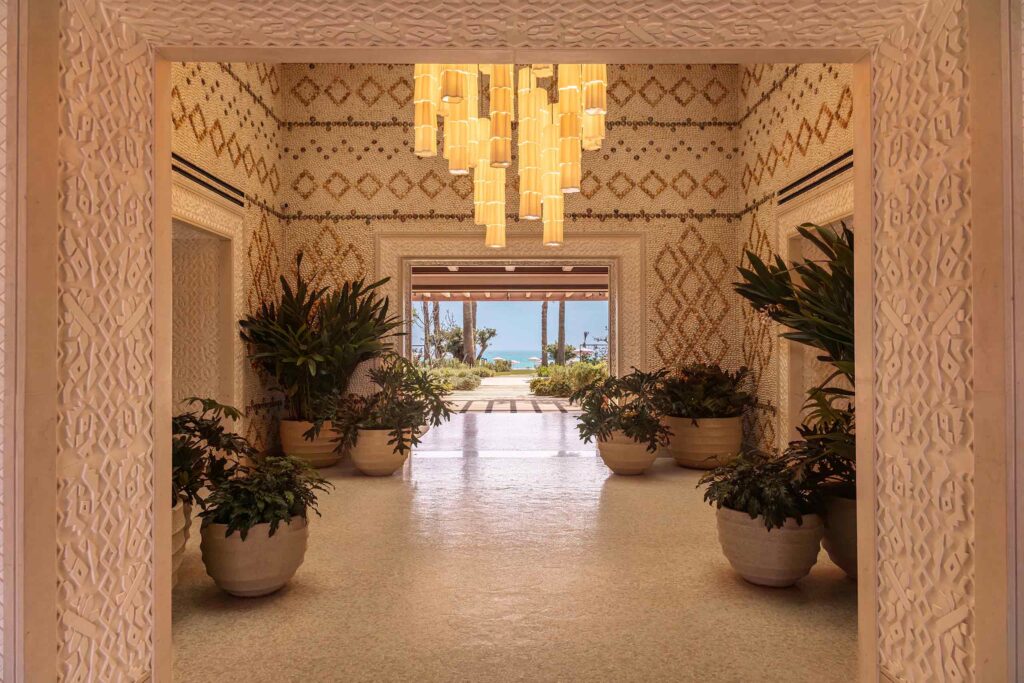 The mosaic-decked arrival area, with potted plants on all sides and a contemporary chandelier at its centre, giving guests a glimpse at the sea straight ahead, Royal Mansour Tamuda Bay, Tamuda Bay, Morocco