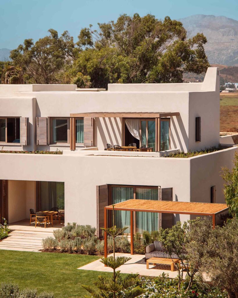 A sand-coloured private villa with an upper floor balcony amidst beautiful landscaping in Northern Morocco