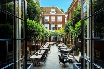 Outside courtyard garden at The Dylan Amsterdam, its brown brick buildings flanking all sides creating a sanctuary