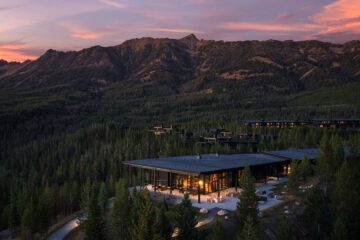 A pink evening sky behind a mountain range surrounded by a forest, at One&Only Moonlight Basin, Big Sky, Montana, USA