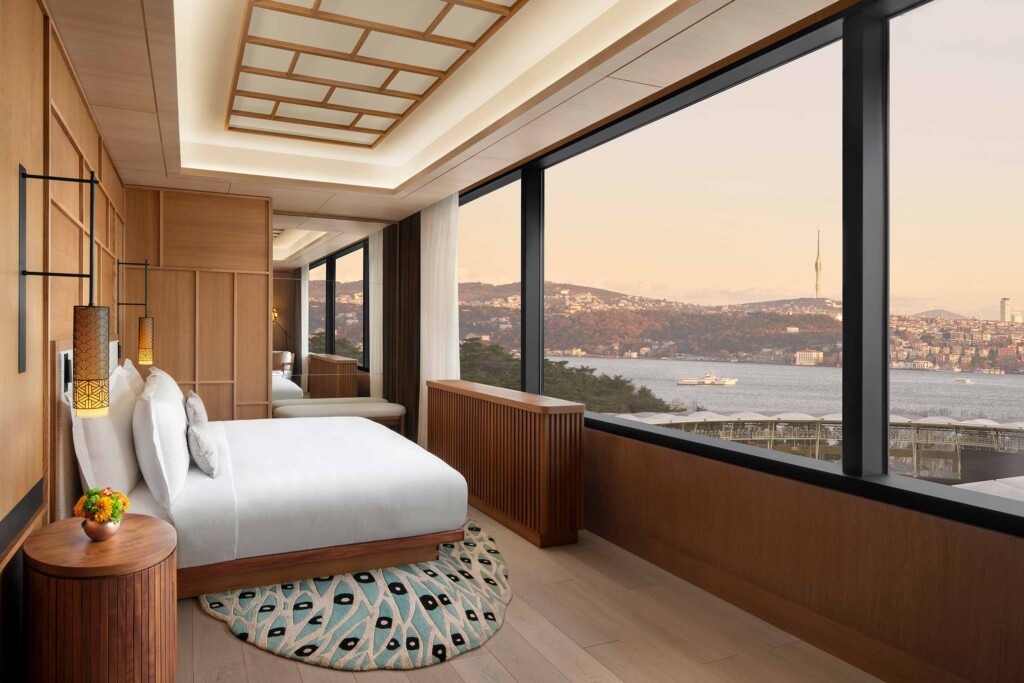 A king-size bed decked in white linen in a Japanese-styled room looks out over the city at The Ritz-Carlton, Istanbul, Türkiye