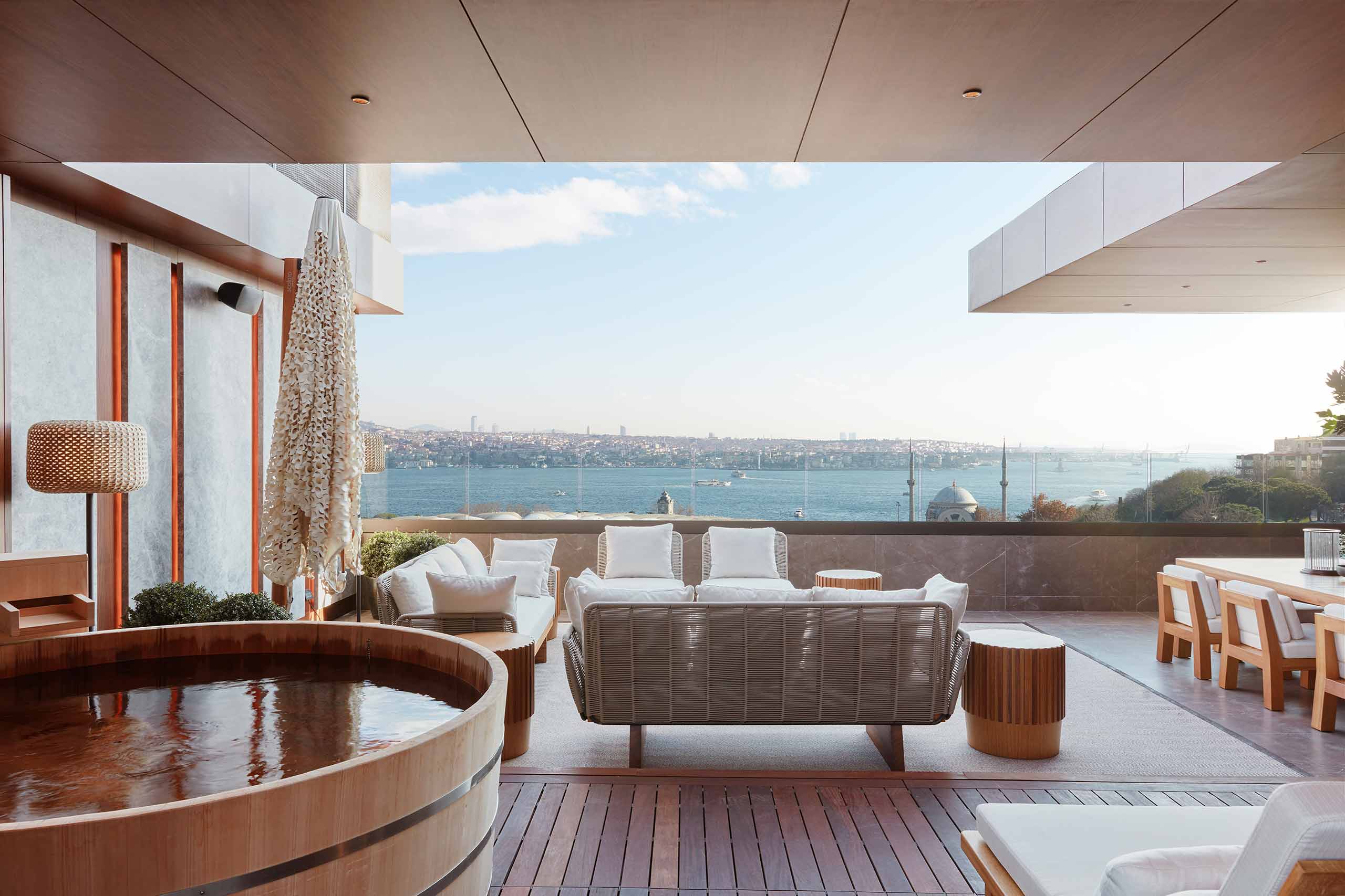 An ofuro bathtub and a large outdoor seating area on the private terrace of the Nobu Suite at The Ritz-Carlton, Istanbul, Türkiye