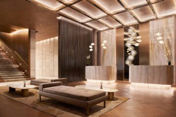 A contemporary seating area sits across from two reception desks in an atmospherically illuminated lobby kept in beige and brown tones at JW Marriott Hotel Mexico City Polanco, Mexico City, Mexico